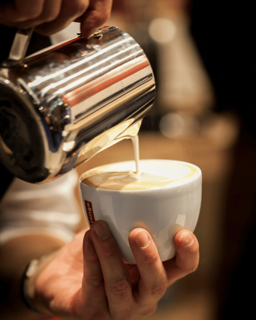 Barista prépare un cappucino et latte art